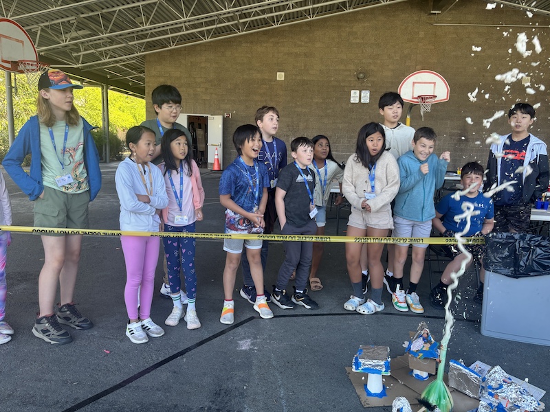 Bellevue Summer Camps Wise Camps campers and volunteers watching a demonstration at the Natural Disasters and Engineering station.