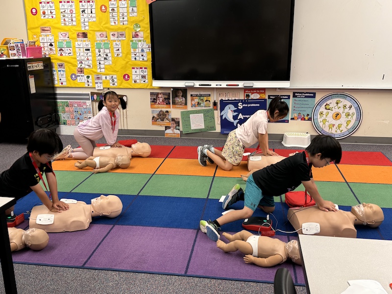 Bellevue Summer Camps Wise Camps campers practicing CPR at the Rescue Ready station.