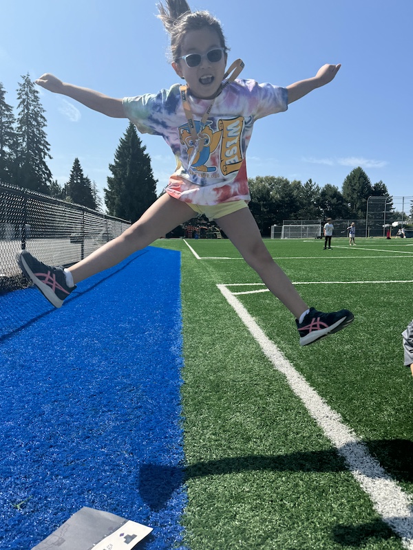 Bellevue Summer Camps Wise Camps camper jumping in the air at the Sports Sampler station.